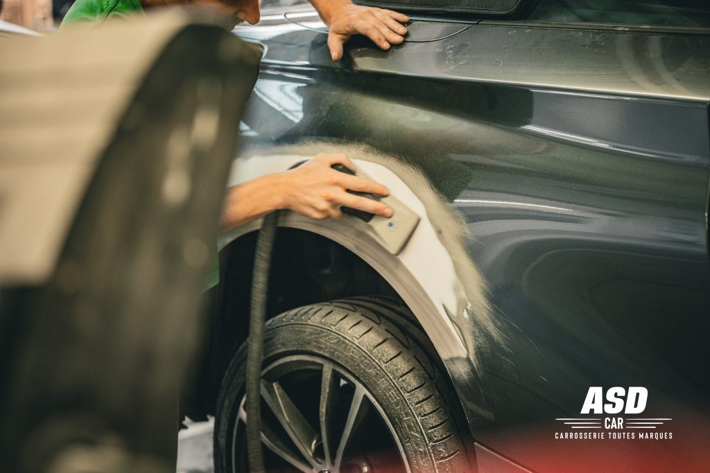 Ponçage de la partie de carrosserie positionnée au-dessus de la roue